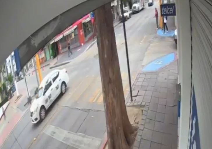 VIDEO: Discusión termina mal; taxista arrastra a biker y lo estrella en un poste